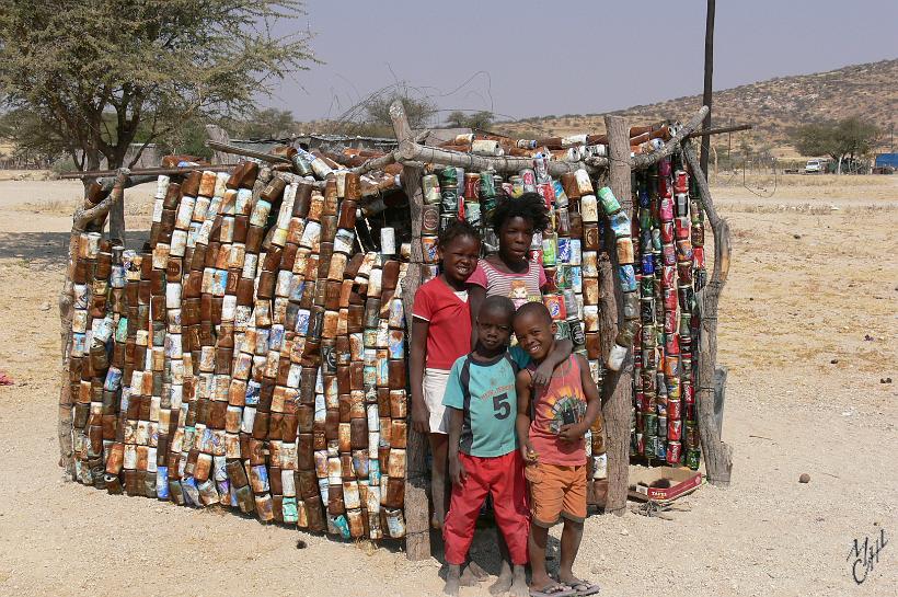 P1130702.JPG - Village de Spitzkoppe. Un petit abri construit en boites de soda. Il y avait aussi une petite table avec quelques cailloux que ces enfants essaient de vendre aux touristes de passage.